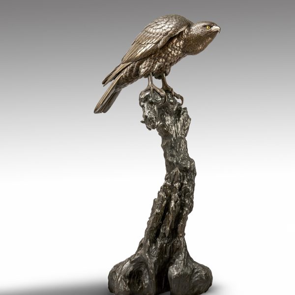A bronze study of a hawk on a gnarled stand